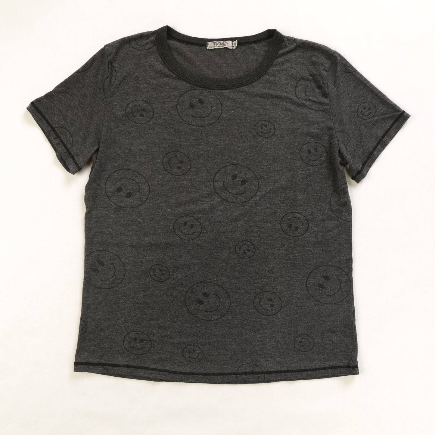 women's simple black t-shirt with larger and smaller happy faces spaced out and randomly distributed across the fabric