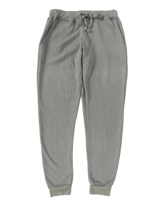 women's light gray sweatpants with front pockets and elastic cuffs at the ends of the pant legs and drawstring tied into a bow at the front of the waistband