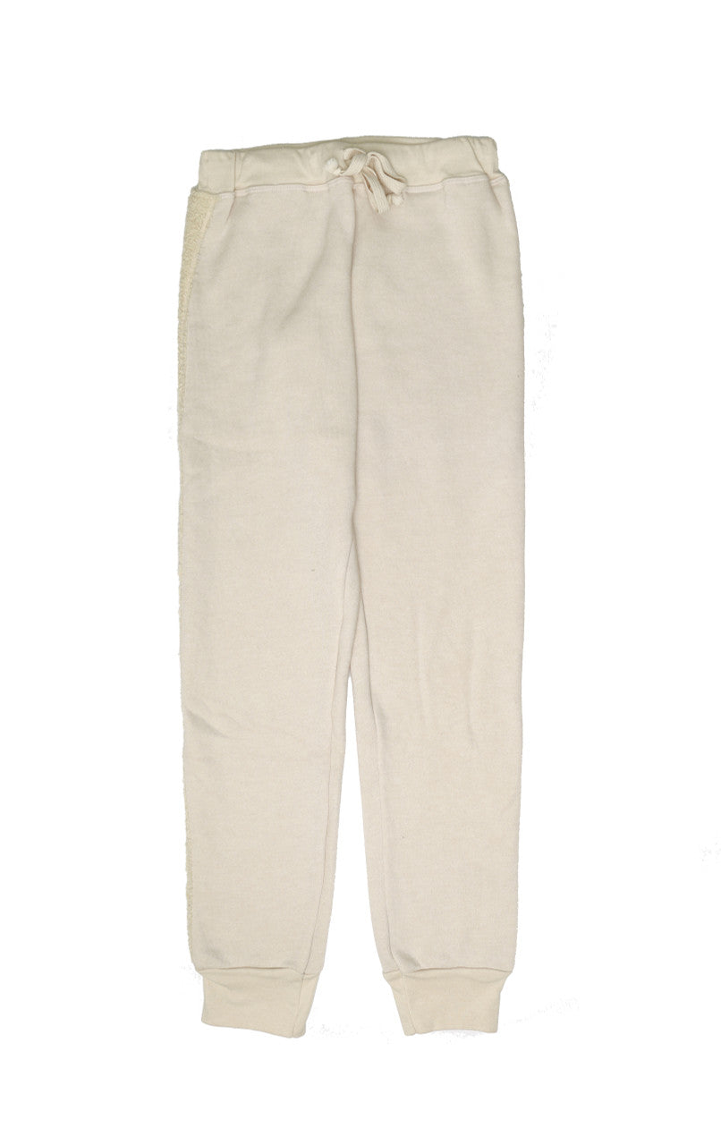 women's cream sweatpants with elastic cuffs at the ends of the pant legs and drawstring tied into a bow at the front of the waistband with reversed fuzzy fabric trim down the outer-sides of the pant legs